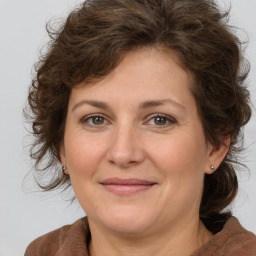 Frau, braune Haare, braune Augen, Ohrringe, brauner Pullover